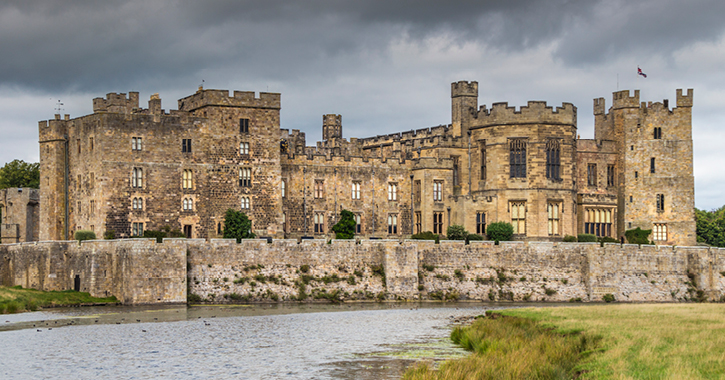Exterior of Raby Castle on a cloudy day with pond in foreground